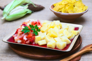 Boiled one-inch chunks of yuca on a white plate, next to something that looks like squid.