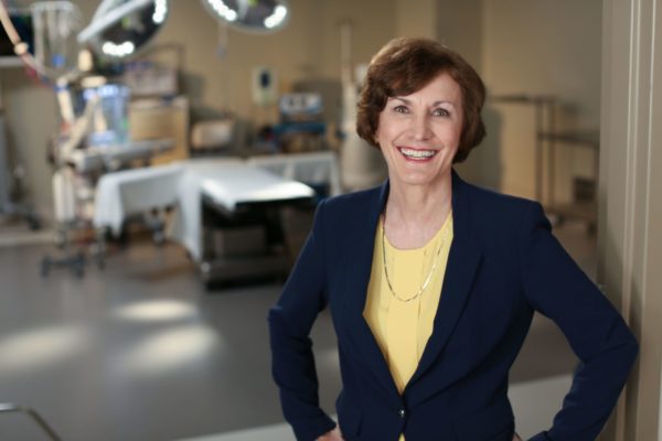 Confident, radiant, smiling Barbara Boiller in a surgical suite looking directly at the viewer