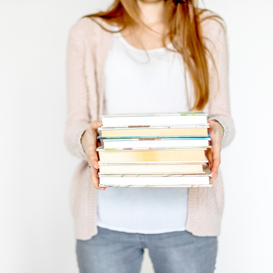 book censorship - photograph of woman holding a stack of books