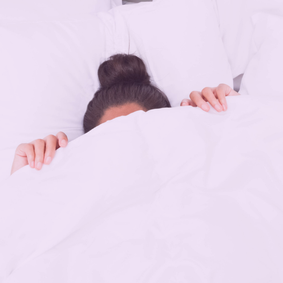 woman hiding under the covers