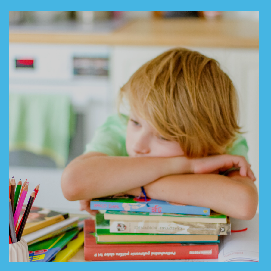 photograph of an unhappy child resting on a stack of books, surrounded by an aqua border