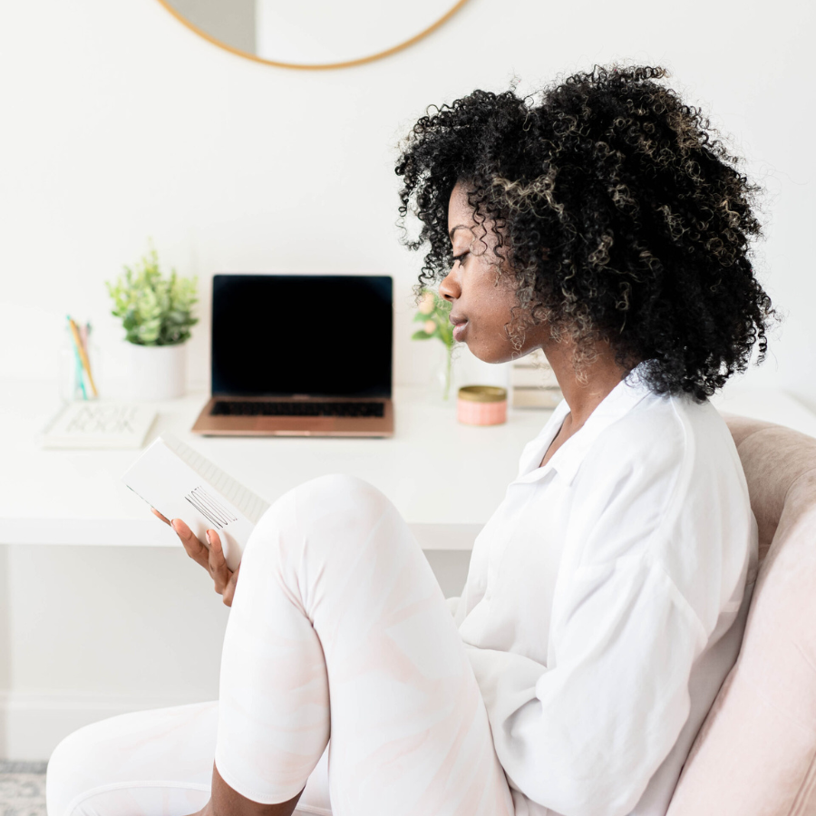 racism in america - black woman wearing all white sits alone on a couch