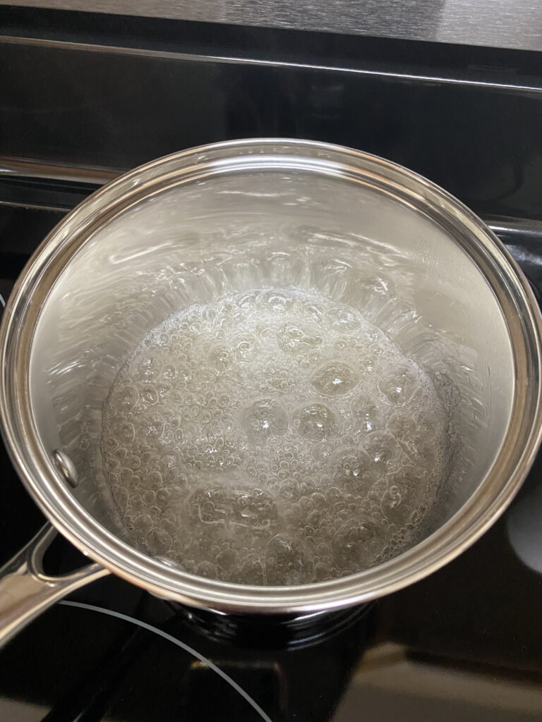 sugar in water boiling in a saucepan to make caramel sauce