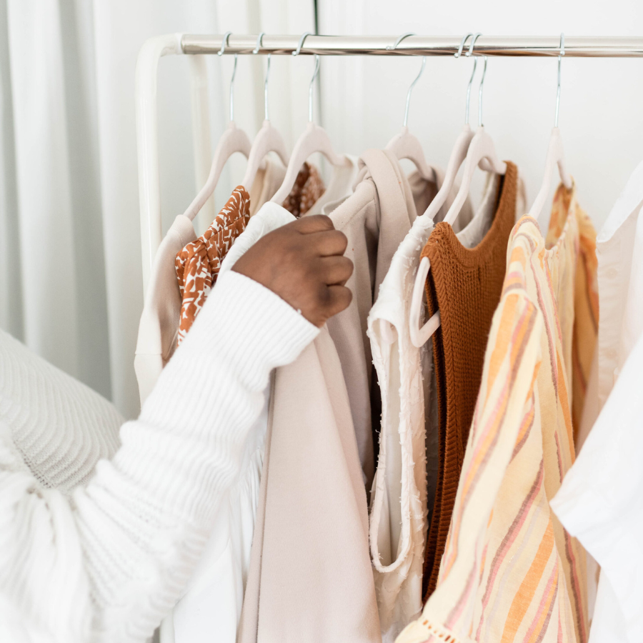 Dressing Sustainably While Fat - photo of woman's arm as she goes through items in a closet