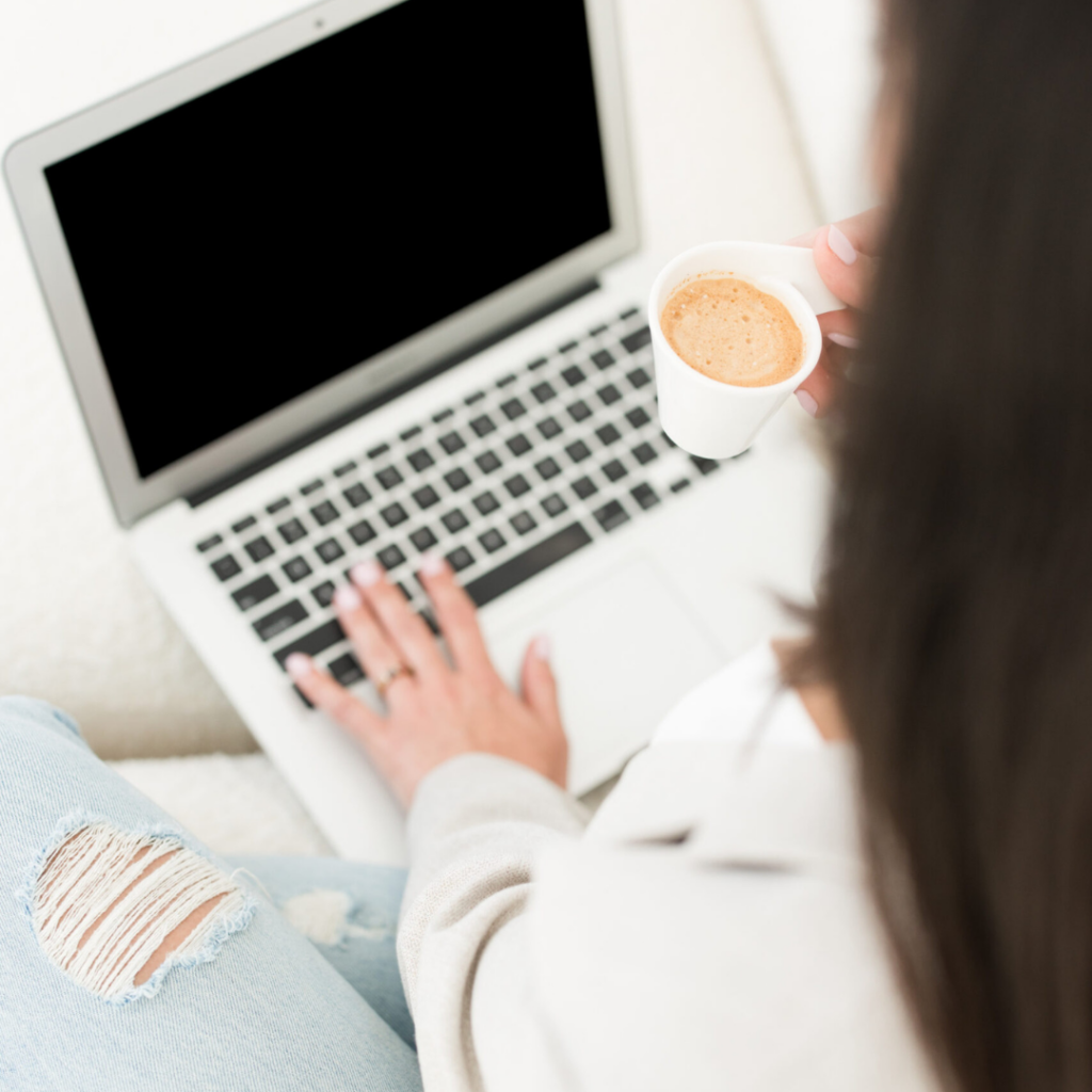 A woman on her computer drinking coffee