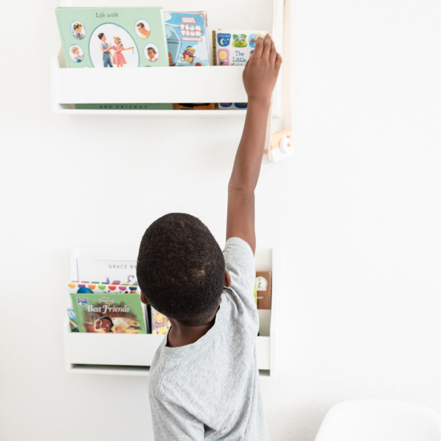 parental rights - Black child reached up to retrieve a book from a shelf