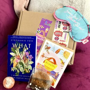 Feminist Book Club's May box with all the contents displayed on a couch.