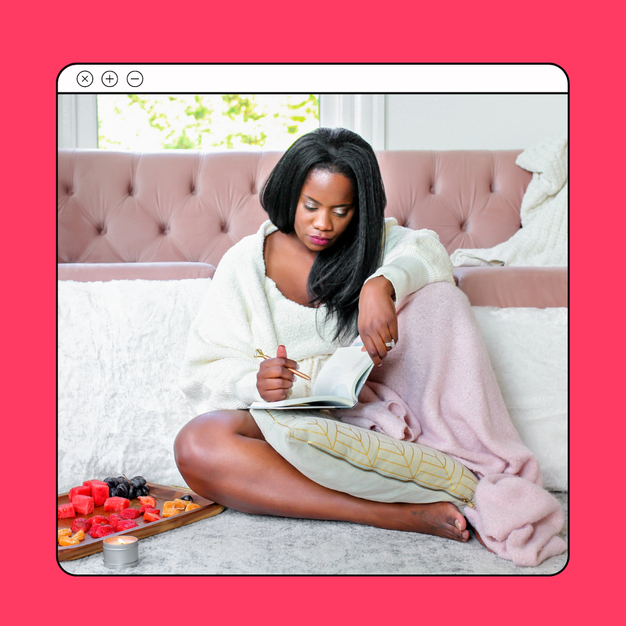 woman reading a book, with pen in hand. A candle and plate of fruits are in from tof her.